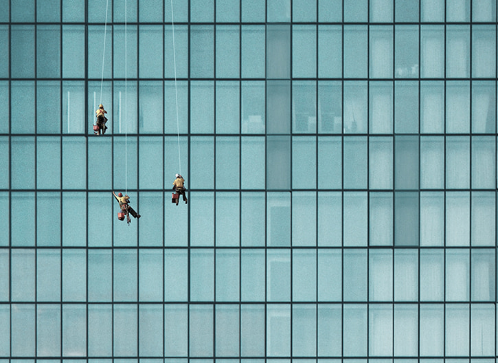 Window cleaners cleaning windows on a big skyrise